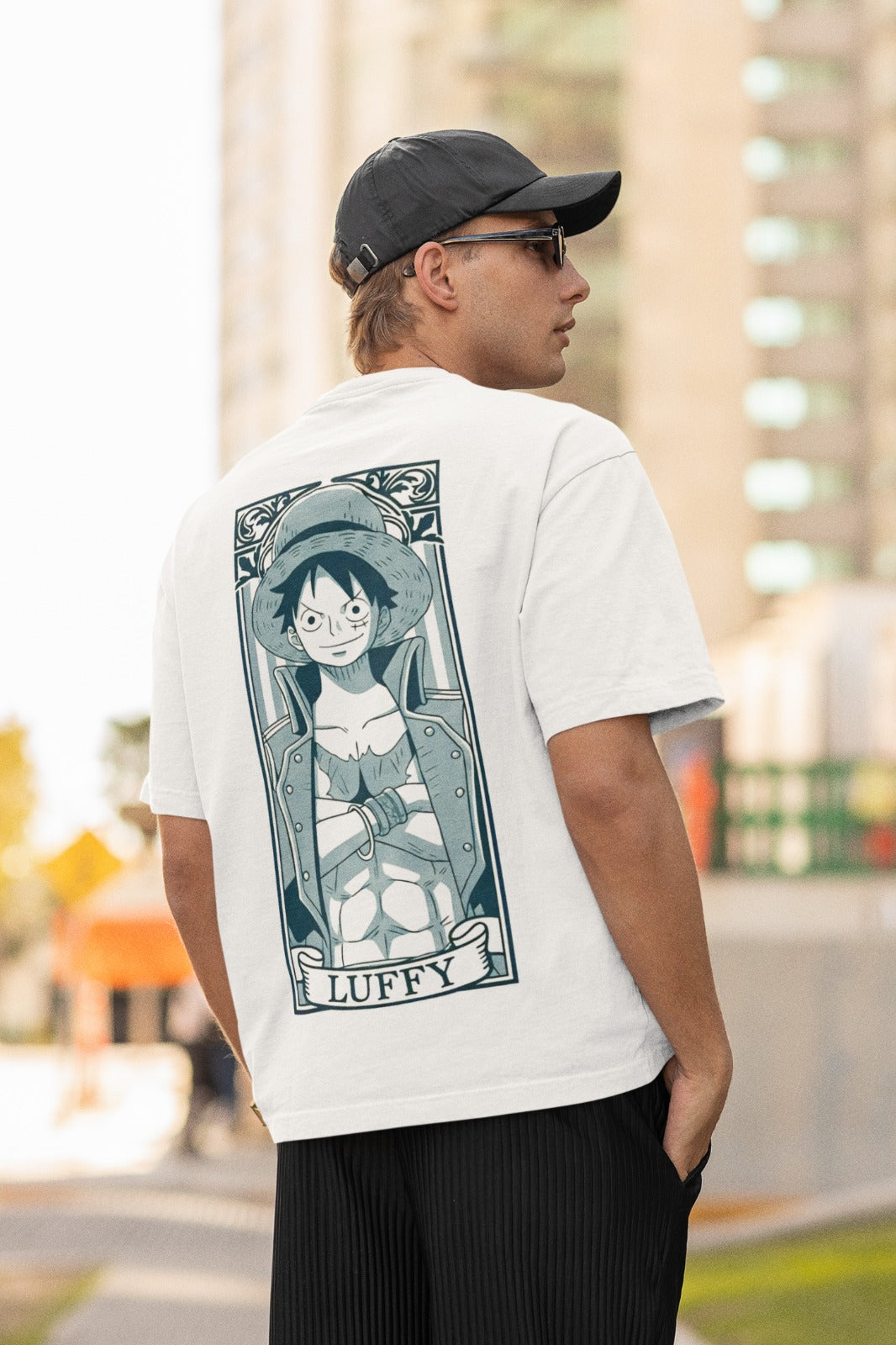 Unleash your inner pirate with our white unisex oversized t-shirt featuring a monochrome design of Luffy in a powerful stance, arms crossed in cartoon grey. His name is creatively written like a banner, adding authenticity. Crafted for style and comfort, this trendy tee is a must-have for One Piece fans. Make a bold fashion statement and showcase your love for Luffy with this unique t-shirt.
