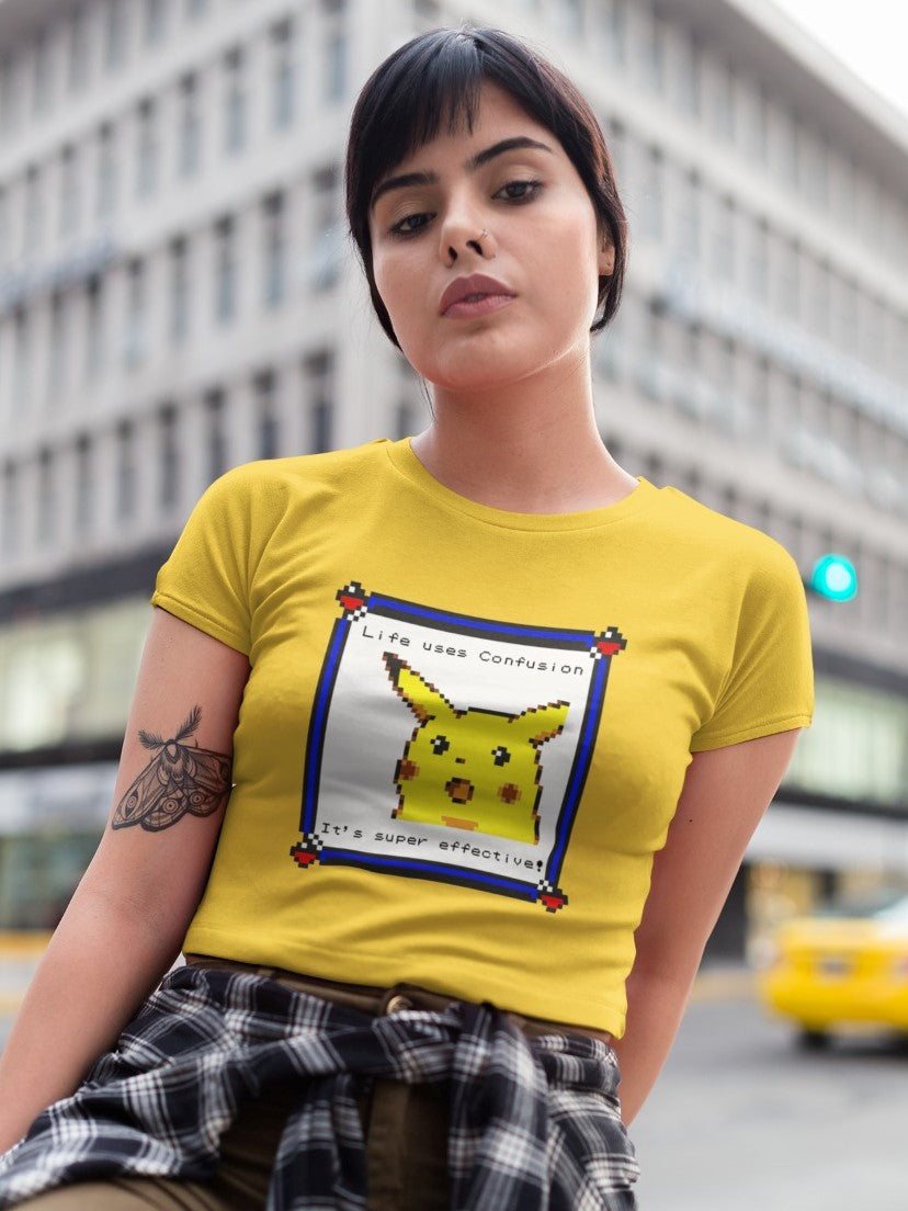 girl with cropped hair and moth tattoo on right hand wearing a yellow crop top with console style picture of surprised pikachu with the message "Life uses confusion, It's super effective" printed on it