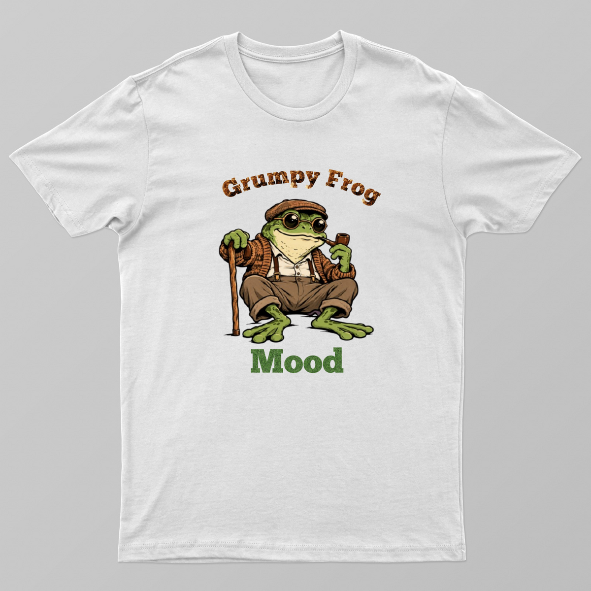 A grumpy frog wearing a cap, glasses, and sweater sits with a cane and pipe. The text above reads "Grumpy Frog" and belo Unisex T-shirt by Kumar Thakur 
