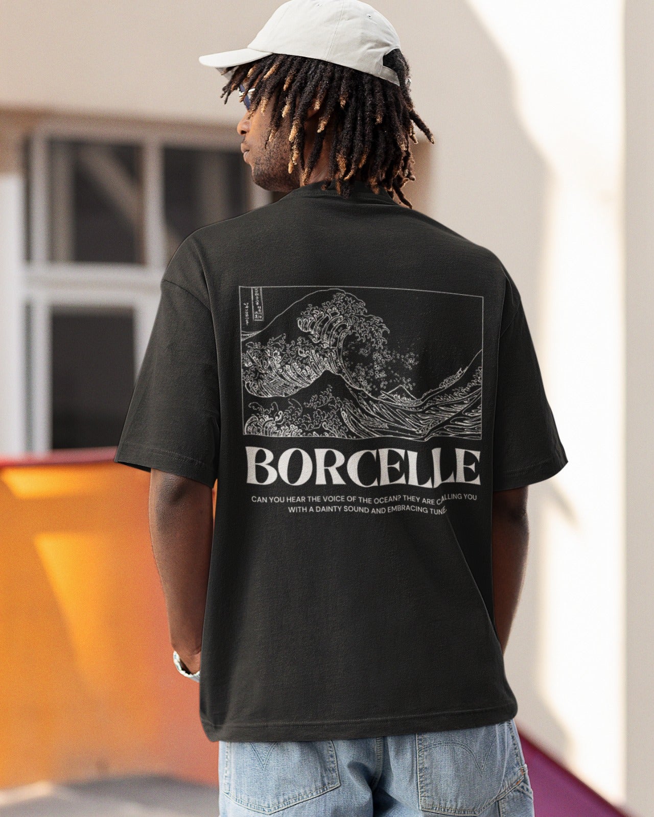 Elevate your style with our Premium Black Oversized T-Shirt featuring a stunning Japanese-style wave painting on the back, titled "BORCELLE." Below, a poetic caption reads, "Can you hear the voice of the ocean? They are calling you with a dainty sound and embracing tune." Crafted with meticulous attention to detail, this tee is both a fashion statement and a work of art, connecting you to the ocean's soothing melodies. Order yours today and embrace the beauty of nature in style.