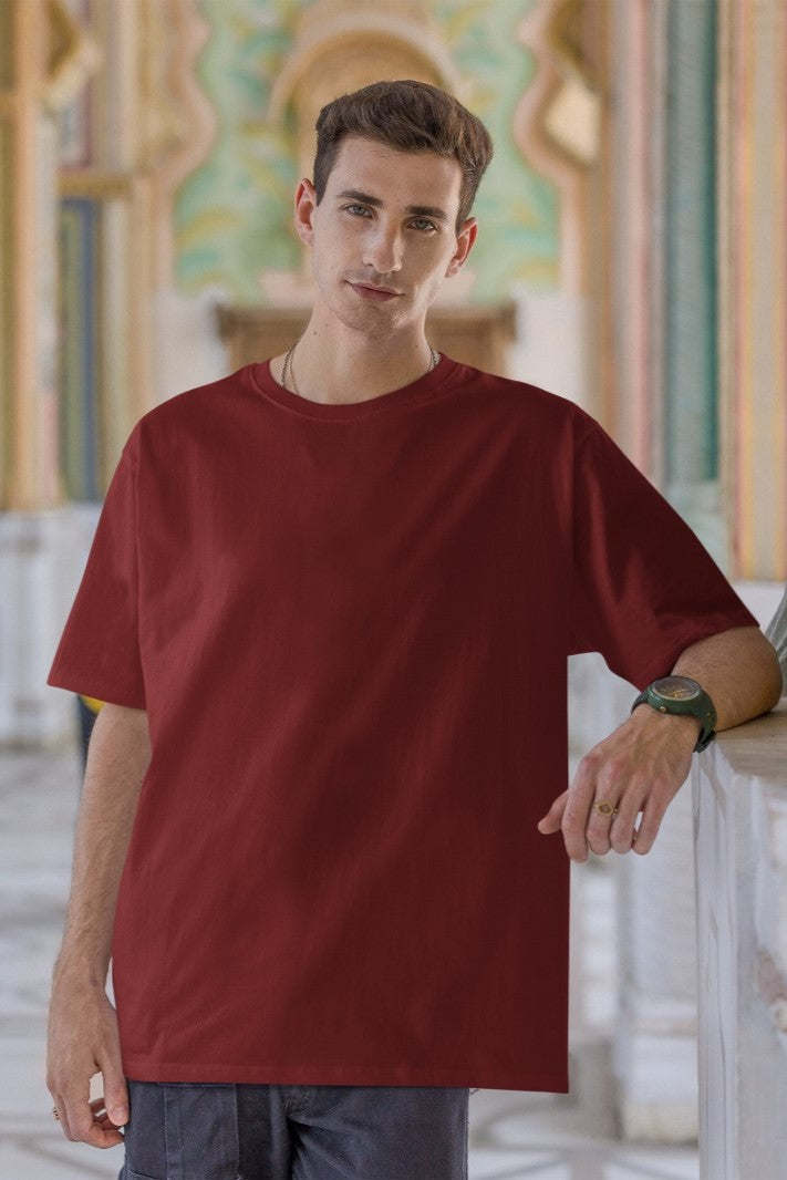 In this image, a stylish guy effortlessly showcases his fashion-forward sensibility in our Premium Heavyweight Maroon Oversized Tee. Its deep maroon hue perfectly complements his timeless jeans, creating a bold and comfortable look. Accentuating his style, a wristwatch adds a touch of sophistication. The oversized tee drapes casually, capturing both comfort and a trendy, laid-back charm that reflects his confident fashion choices.