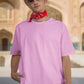 In this striking image, a confident and stylish guy dons our Premium Heavyweight Baby Pink Oversized Tee, exuding effortless cool. He elevates the look with a vibrant red bandana stylishly tied around his neck, adding a dash of attitude. Fashionable shades protect his eyes, and a trendy hat completes the ensemble. His outfit harmoniously blends comfort and flair, making a bold and memorable fashion statement.