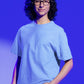 In this endearing image, a nerdy-looking boy sporting stylish glasses embodies a unique blend of comfort and fashion. He confidently rocks our Premium Heavyweight Baby Blue Oversized Tee, its relaxed fit exuding a cool, laid-back vibe. His choice of attire complements his smart and unassuming style, making a subtle yet distinctive fashion statement. The baby blue tee reflects his penchant for comfort without compromising on a touch of personal flair.