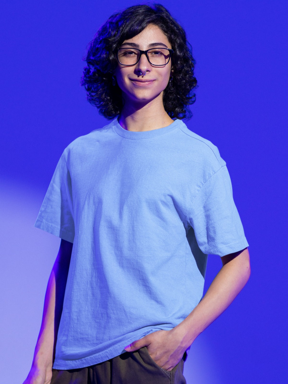 In this endearing image, a nerdy-looking boy sporting stylish glasses embodies a unique blend of comfort and fashion. He confidently rocks our Premium Heavyweight Baby Blue Oversized Tee, its relaxed fit exuding a cool, laid-back vibe. His choice of attire complements his smart and unassuming style, making a subtle yet distinctive fashion statement. The baby blue tee reflects his penchant for comfort without compromising on a touch of personal flair.