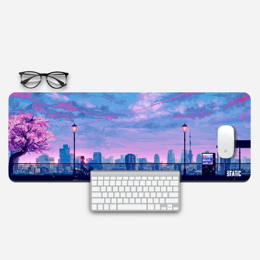 Elevate your gaming experience with our anime-inspired extended gaming mouse pad. Immerse yourself in a vibrant world of pink and blue city skylines, with a serene park and a young cyclist amidst blooming cherry blossoms. This unique design adds a touch of anime magic to your gaming setup. Enjoy precise mouse control and a visually stunning desktop accessory. Upgrade your gaming experience with a touch of artistry. Grab this exclusive mouse pad today and let your imagination soar in the world of gaming.
