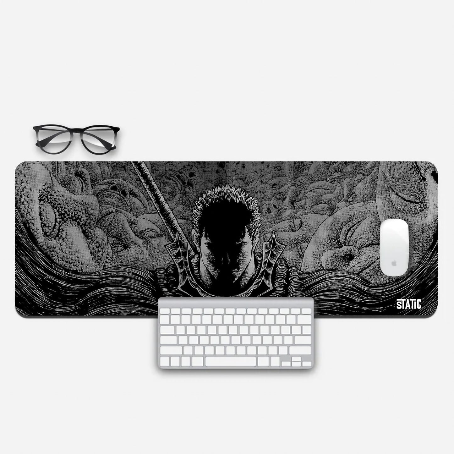 Embark on a relentless gaming journey with our extended mouse pad, featuring Guts from Berserk. This striking black and white design highlights Guts' determined face, his sword poised for action, amidst eerie large faces in the background. A dark shadow adds intensity to the scene. Immerse yourself in the gripping world of Berserk and elevate your gaming prowess. Order now to channel Guts' unwavering resolve in your gaming battles.