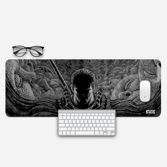 Embark on a relentless gaming journey with our extended mouse pad, featuring Guts from Berserk. This striking black and white design highlights Guts' determined face, his sword poised for action, amidst eerie large faces in the background. A dark shadow adds intensity to the scene. Immerse yourself in the gripping world of Berserk and elevate your gaming prowess. Order now to channel Guts' unwavering resolve in your gaming battles.