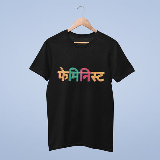 Celebrate empowerment and equality with our Black Cotton Round Neck T-shirt featuring the word "Feminist" written in vibrant, multicolored Hindi script. Made from high-quality cotton, this tee offers both style and comfort. Make a bold statement while advocating for gender equality. Whether you're at a rally, social gathering, or just expressing your beliefs, this shirt is the perfect choice. Show your support for feminism with fashion-forward flair. Get yours today and wear your values proudly.