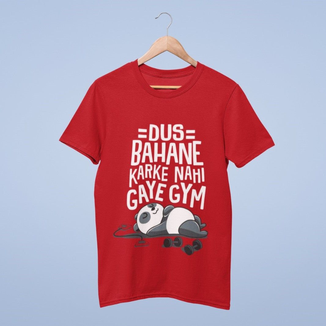 Elevate your casual wardrobe with our Red Cotton Round Neck T-shirt. It features a witty graphic design, showcasing the phrase "Dus Bahane Karke Nahi Gaye Gym" (Didn't go to the gym with ten excuses) and a charming panda resting beside dumbbells. Crafted from premium cotton, this tee combines comfort and durability. Whether you're hitting the gym or want a playful look, this shirt delivers a fun and relaxed vibe. Embrace the panda's carefree spirit and add humor to your style today!