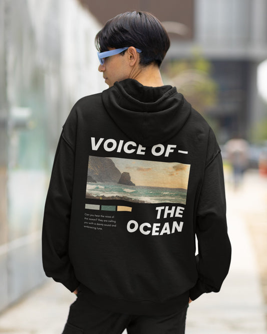 Indulge in seaside serenity with our Black Oversized Hoodie. Its back showcases a pastel-hued coastal scene, transporting you to the tranquil ocean's edge. The caption "VOICE OF THE OCEAN" adds a touch of nature's soothing melody. This hoodie isn't just apparel; it's a gateway to calm. Ideal for style and comfort, it's perfect for any occasion. Elevate your wardrobe and embrace the ocean's gentle whispers today.