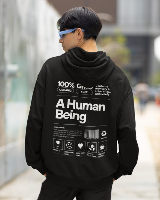 Elevate your wardrobe with our Black Oversized Hoodie, featuring a humorous product label design that defines "A Human Being." With tags like "Fragile," "Emotional Being," and "Made with Love," it captures the essence of human complexity. Playfully stating "Requires Coffee" and claiming "100% GMO, Organic & Free," it's a fun and relatable statement piece. Express your unique personality with this stylish and witty hoodie.