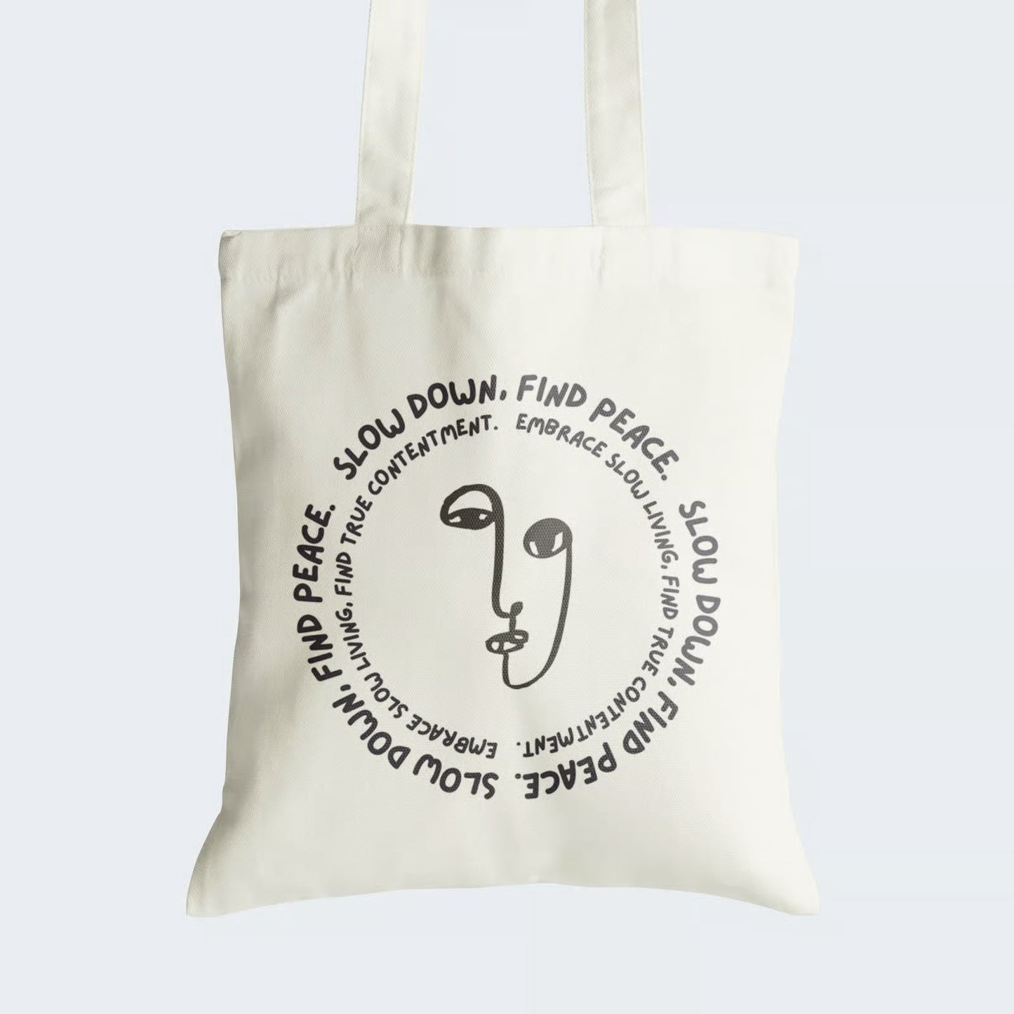 Elevate your style and embrace mindfulness with our "Slow Down, Find Peace" Cotton Canvas Tote Bag. This tote features a tranquil line art face, encircled by two concentric messages: "Slow Down, Find Peace" and "Embrace Slow Living, Find True Contentment." Crafted for durability and style, it includes a secure zipper closure for daily convenience. Carry the message of inner serenity and mindfulness with our meaningful Cotton Canvas Tote Bag. Order yours today and find peace in every step!