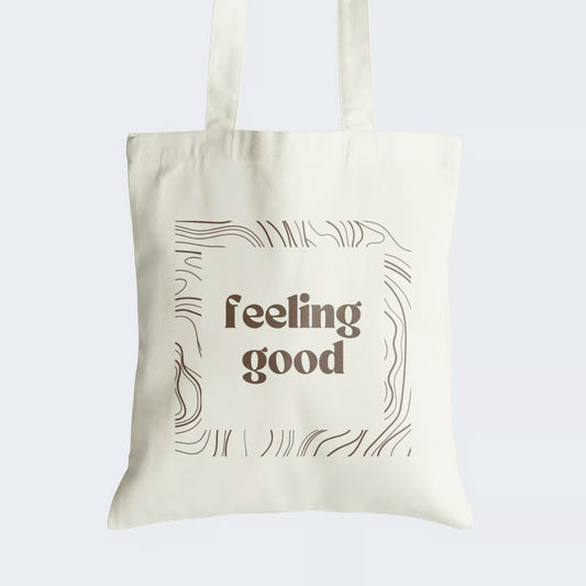 Elevate your style and embrace positivity with our "Feeling Good" Cotton Canvas Tote Bag. This tote boasts an empowering graphic text, "Feeling Good," encased within an intricately designed line art frame, harmonizing artistry with optimism. Crafted for both durability and style, it includes a secure zipper closure for daily convenience. Carry the message of positivity and artistic elegance with our stylish Cotton Canvas Tote Bag. Order yours today and spread good vibes wherever you go!