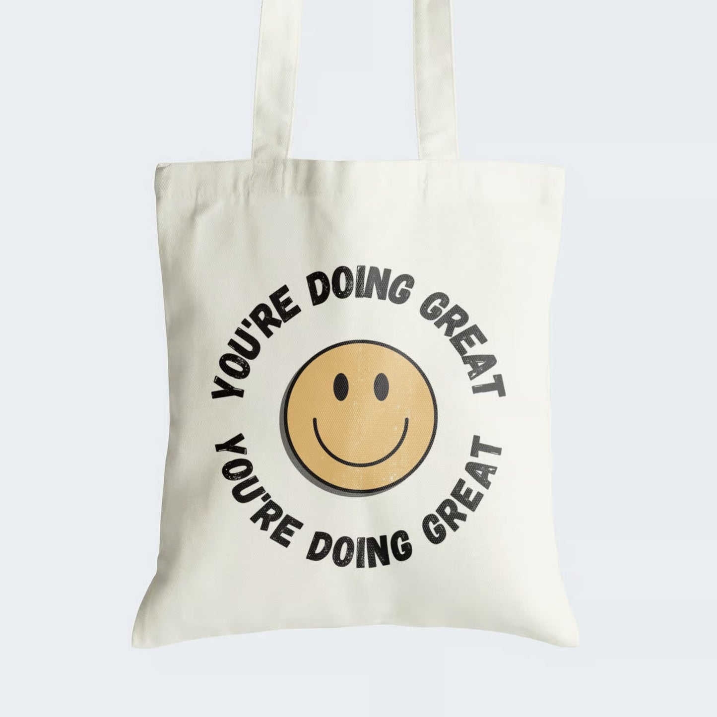  Elevate your style and spirits with our Cotton Canvas Tote Bag. It boasts an inspiring design featuring a cheerful smiley, encircled by the uplifting phrase "You're Doing Great" above and below. This tote combines style with functionality, featuring a secure zipper closure. By choosing this reusable tote, you not only celebrate positivity but also embrace sustainability. Carry encouragement and charm wherever you go with our "You're Doing Great" Cotton Canvas Tote Bag. Order yours today!