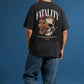 Person wearing a black t-shirt with a skull and floral design on the back against a blue background
