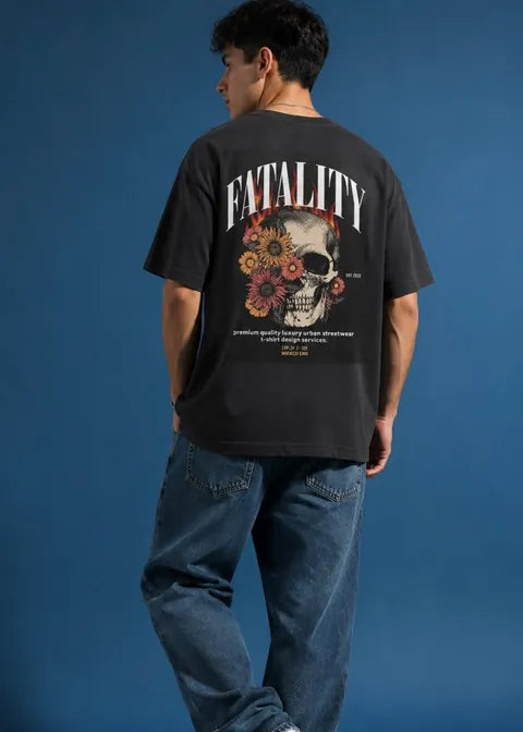 Person wearing a black t-shirt with a skull and floral design on the back against a blue background