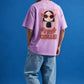 Person wearing a pink t-shirt with a graphic design and text on the back against a blue background