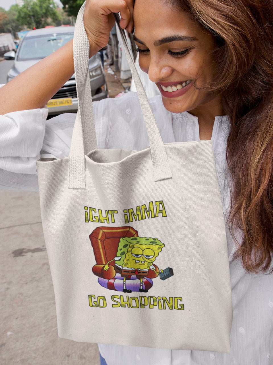 smiling woman holding a canvas tote bag with a picture of spongebob getting off the sofa saying right I'mma go shopping, relatable memes