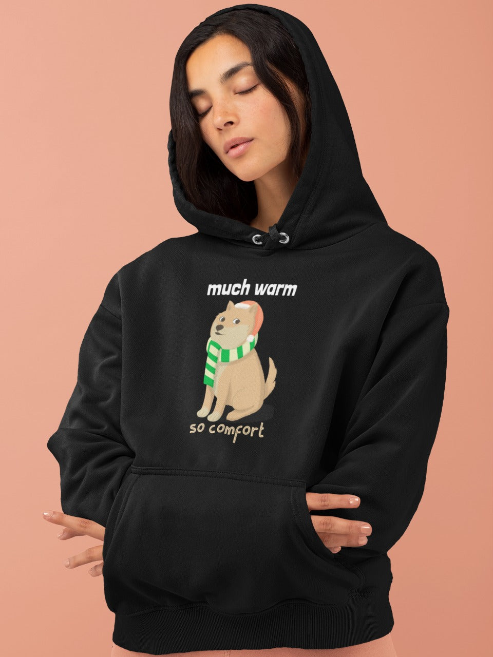 girl in relaxed mood wearing a black hoodie with picture of cute doggo wearing a scarf printed on it with the message much warm so comfort