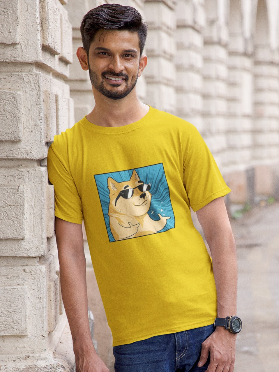 lightly bearded man standing against a wall wearing a yellow tshirt with a shiba inu wearing black shadesin a cool pose with both thumbs pointing forward printed on it, swagger funny memes