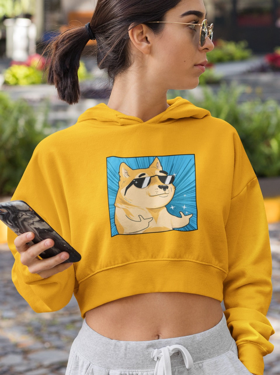 girl wearing golden sunglasses and a yellow crop-hoodie with a shiba inu wearing black shades in a cool pose with both thumbs pointing in forward and shining printed on it, swagger funny memes
