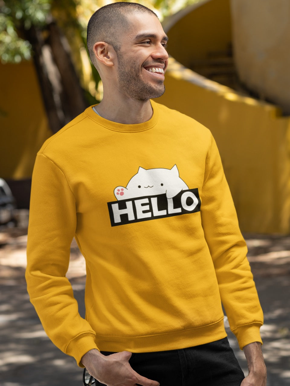 smiling man with trimmed hair and beard wearing a yellow sweatshirt with bongo cat saying hello printed on it, cute funny memes