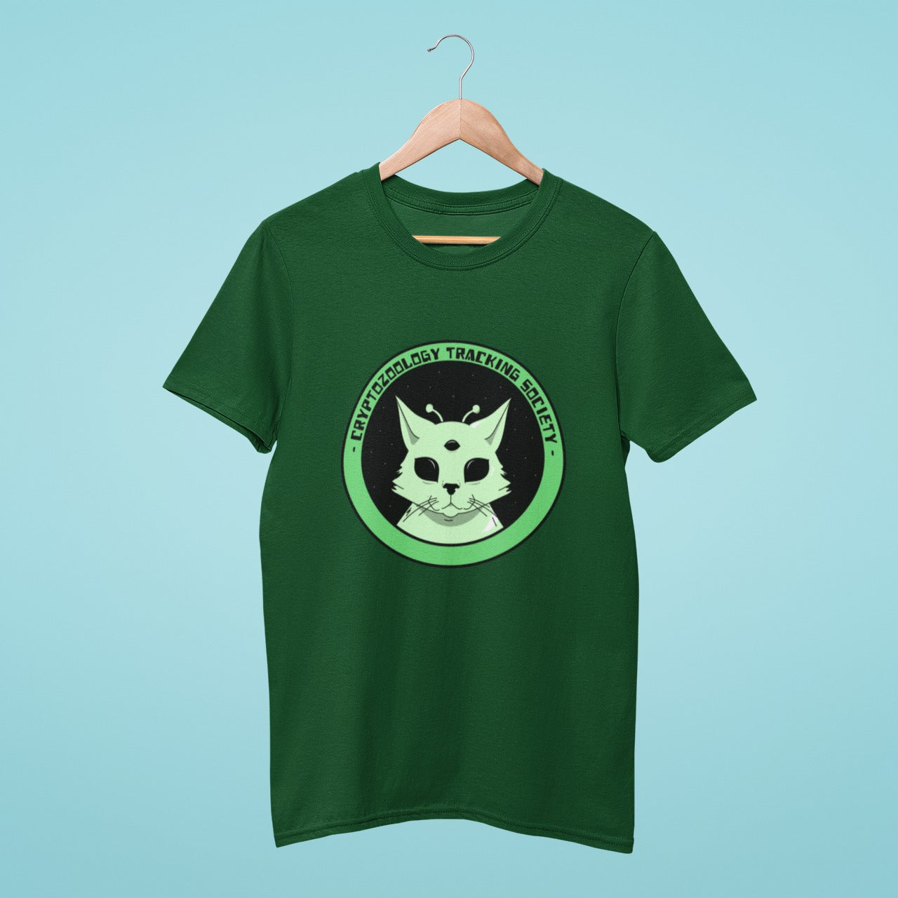 Add some intergalactic charm to your wardrobe with our green t-shirt featuring an alien-like cat and the title "Cryptozoology Tracking Society". Perfect for sci-fi and cryptozoology enthusiasts who also love playful fashion. Made from high-quality materials, this comfortable and durable t-shirt is a must-have. Order now and show off your quirky style!