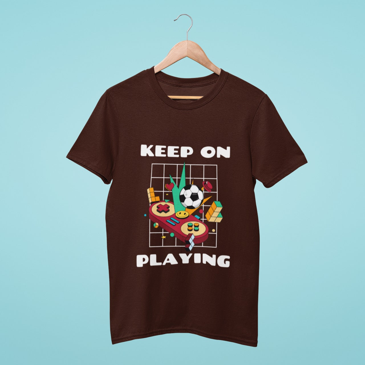 Unleash your gaming spirit with this brown t-shirt featuring a playful joystick with games around it in the centre, and a motivating "Keep on Playing" slogan. Perfect for gamers who never back down from a challenge and keep pushing for their victory.